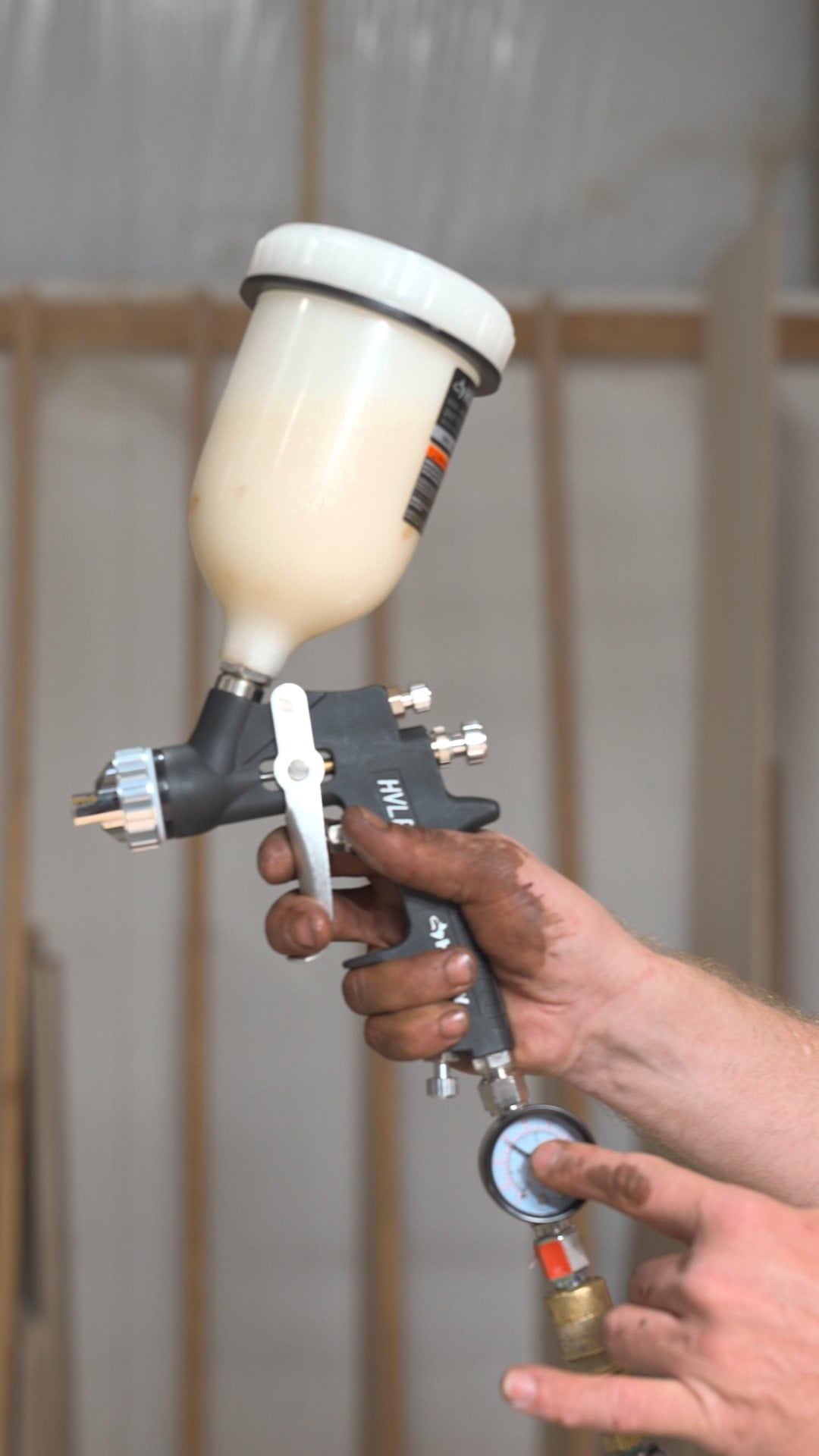 Budget HVLP cup spray gun with an inline pressure regulator for spraying cabinets