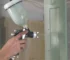 how to paint unfinished cabinets: spraying a raw birch shaker door with a cup gun